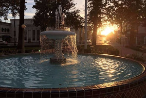 Fountain in a park with sunset in the background