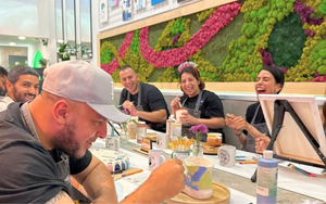 Group of people sitting around a table with a colorful wall art in the background